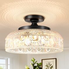 a chandelier hanging from the ceiling above a dining room table with flowers on it