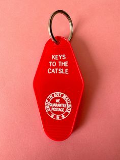 a red keychain with the words keys to the castle printed on it