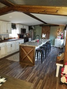 an open kitchen and dining room with wood flooring, white cabinets and counter tops