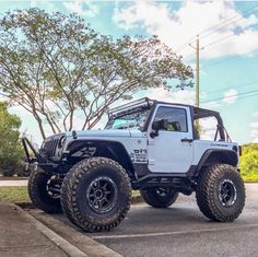 a white jeep is parked on the street