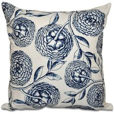 a blue and white pillow with large flowers on the front, sitting on a white surface