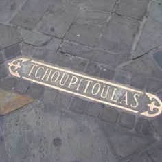 a street sign that is on the side of a brick road with an arrow pointing to it