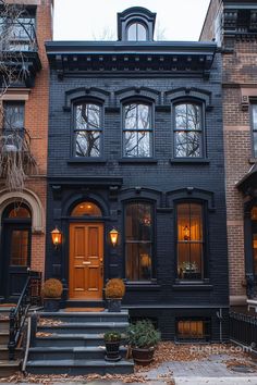 an old black house with many windows and steps leading up to the front door in autumn