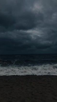 dark clouds hover over the ocean on a stormy day