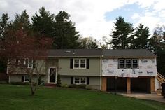 a house under construction with a truck parked in front of it and trees behind it