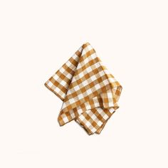 two brown and white checkered napkins sitting on top of each other