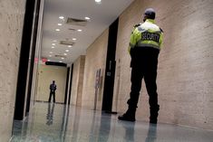 two security officers standing in an empty hallway