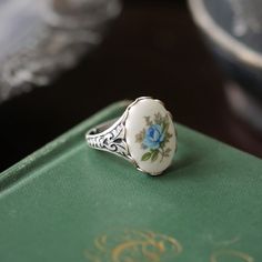 Victorian style antiqued ring which is fully adjustable. At its center is an 18x13mm vintage blue rose cameo. Available in both antiqued brass and antiqued silver. Vintage Rose Design Jewelry As A Gift, Vintage Oval Jewelry With Rose Design, Vintage Rose Design Jewelry For Formal Occasions, Vintage Sterling Silver Jewelry With Rose Design, Victorian Oval Enamel Ring As Gift, Victorian Oval Enamel Ring As A Gift, Vintage Ring With Rose Design, Vintage Rose Design Rings As Gift, Vintage Rings With Rose Design For Gift