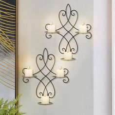 three candle holders are hanging on the wall