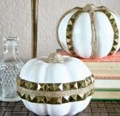 two white pumpkins sitting on top of a table next to books and glass bottles