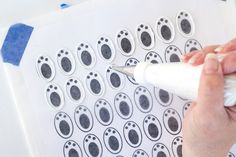 a person is using a marker to draw footprints on paper with black and white ink