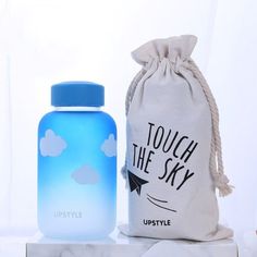 a blue water bottle sitting next to a white bag