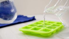 a plastic ice tray filled with water on top of a table