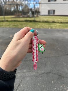 a person is holding two keychains in their left hand and one has a green face on it