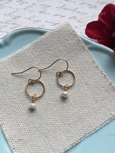 Pearl Circle Earrings. These beautiful small hoop earrings feature a single 4-5 mm freshwater pearl wire wrapped onto a gold-filled hoop. The hoop is approximately 6 mm. The hoops and French wires are gold filled. Pearl is the June birthstone. Your earrings will arrive in a gift box. If this is a gift, I would be happy to include a card with your personal message - just let me know in the message section at checkout. Gold Pearl Drop Cartilage Earrings As Gift, Handmade Round Elegant Cartilage Earrings, Small Hoop 14k Gold Filled Pearl Earrings, Dainty Small Hoop Jewelry For Anniversary, Dainty Nickel-free Earrings, Hypoallergenic 14k Gold Filled Earrings For Anniversary, Anniversary Jewelry With Matching Earrings, Delicate Dangle Cartilage Earrings With Ear Wire, Dainty Small Hoop Nickel-free Earrings