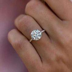 a woman's hand with a diamond ring on it