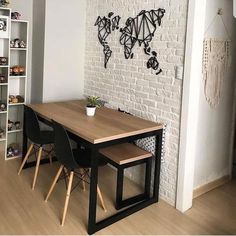 a dining room table with two chairs and a wall map on the wall behind it