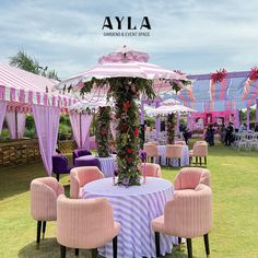 an outdoor event set up with pink and purple striped chairs, umbrellas and tables