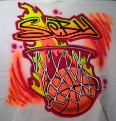 a t - shirt with graffiti on it that has a basketball in the net and flames coming out of it