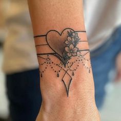 a woman's wrist with a heart and flowers tattoo design on the left hand