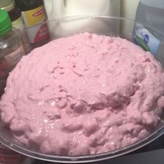 a bowl filled with pink colored food next to milk and other confection items