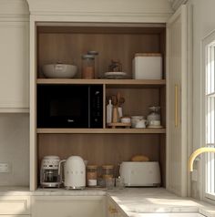 a kitchen with white cabinets and wooden shelves filled with dishes, coffee maker, toaster oven and other items