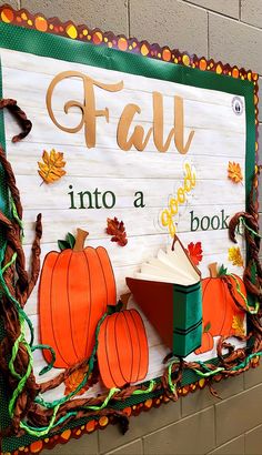 a bulletin board that says fall into a book with pumpkins and leaves around it