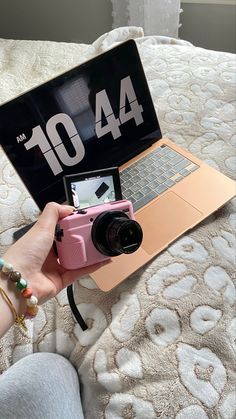 a person sitting on a bed with a camera and laptop