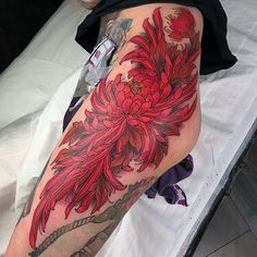 a woman's leg with red flowers on it