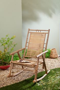 a wooden rocking chair sitting in the grass