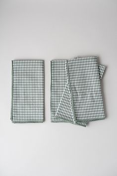 two green and white checkered napkins sitting next to each other