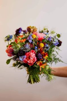 a person holding a bouquet of flowers in their hand