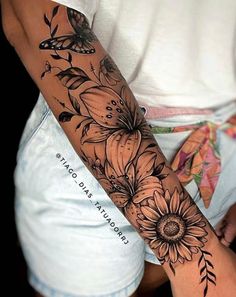 a woman's arm with flowers and butterflies on it