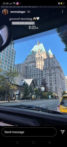 an image of a city street taken from inside a car with buildings in the background