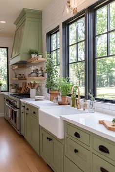 a kitchen filled with lots of green cabinets and counter top space next to large windows