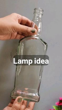 two hands holding a glass bottle that says lamp idea