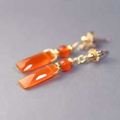 Gold filled, gemstone, vivd, orange color drops. These sweet, short,  gold filled earrings are created with beautiful carnelian baguettes and roundels. The gems are small but just amazing, they are bright in color and are beautifully faceted.  Simple, delicate and elegant, these earrings completed with gold filled ball posts and they measure 1.25 inch top to bottom. Carnelian baguette 5x15mm Thank you for looking! Please contact me if you have any questions or requests. Free domestic First Class Gold Carnelian Dangle Earrings, Elegant Carnelian Dangle Earrings, Elegant Carnelian Drop Earrings, Elegant Orange Earrings With Natural Stones, Orange Gemstone Dangle Earrings, Gold Carnelian Gemstone Earrings, Elegant Orange Carnelian Earrings, Orange Gemstone Drop Earrings, Orange Carnelian Dangle Earrings