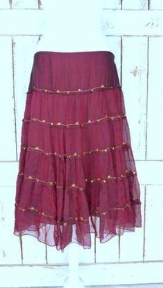 "Vintage sheer silk dark red ruffle midi skirt/mid length tiered festival skirt/90s burgundy/maroon silk skirt/large Features... -sheer 100% overlay -accented with metallic gold threading -stretch poly lining -midi length -zipper side -90's vintage Measurements...taken flat -marked size: large -across waist: 18\" -length: 29\" Condition... -excellent vintage condition -minimal wear UJ2065" Elegant Festive Ruffle Skirt, Festive Elegant Ruffled Skirt, Festive Ruffled Tiered Skirt Dresses, Festive Tiered Ruffled Skirt Dresses, Fall Tiered Ruffled Skirt, Elegant Tiered Summer Skirt, Bohemian Ruffled Skirt For Party, Flowy Full Skirt With Ruffles, Fitted Tiered Dress With Pleated Skirt