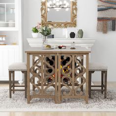 a dining table with two benches and a mirror on the wall above it in a white room