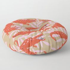 an orange and pink floor pillow with dinosaurs on it