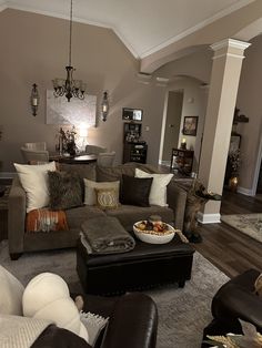 a living room filled with furniture and a chandelier hanging from the ceiling above