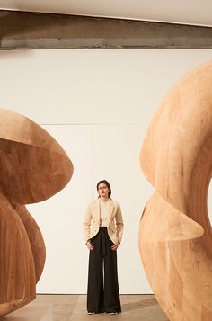 a woman standing in front of wooden sculptures