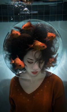 a woman with fish in her hair under water