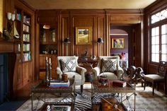 a living room filled with lots of furniture and bookshelves next to a fire place