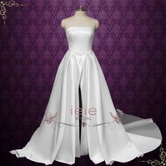 a white wedding dress on display in front of a purple background