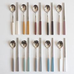 the spoons are lined up in different colors and sizes, with silverware on them