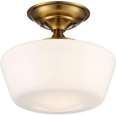 a light fixture with a white glass shade on the bottom and an antique brass finish