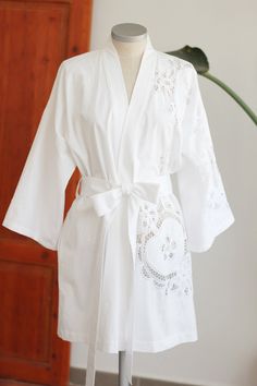 Caroline is a luxurious wrap robe with a relaxed fit made from a vintage Battenberg textile hemmed above the knee with side seam pockets. - SKU: C01S01 - Designed & handmade in Spain - 100% Cotton - Size Small - Hand or machine wash gentle, lay flat to dry - Every textile carries the imprints of its journey through time. All signs of wear, character, stains and mending are reminders of its' history, and original to every carefully curated and preserved textile. Spring Open Front Home Robe, Elegant Spring Cotton Kimono, Relaxed Fit Robe For Home Use In Spring, Summer Robe With Lace Trim For Daywear, Elegant Spring Cotton Robe, Open Front Cotton Robe For Loungewear, Cotton Open Front Robe For Loungewear, Robe With Relaxed Fit And Kimono Sleeves For Daywear, White Wrap Robe For Daywear