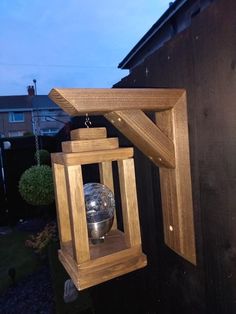 a wooden lantern hanging from the side of a building with a mirror ball in it