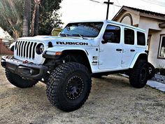 a white jeep parked in front of a house with the word rubion on it